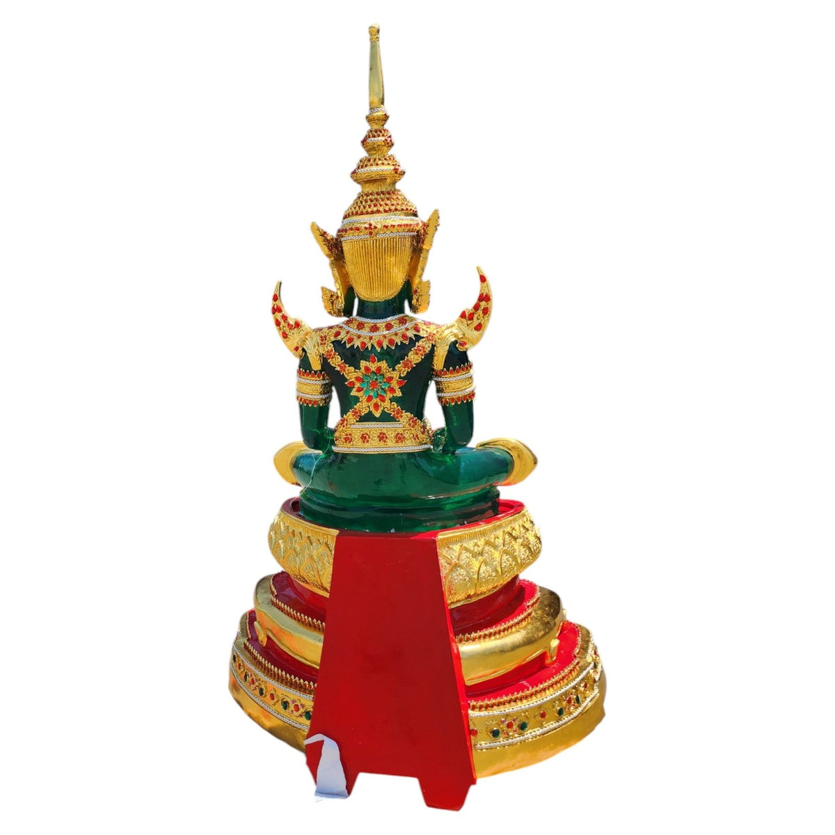 Emerald Buddha replica in green with gold attire on a tiered red and gold base, angled view