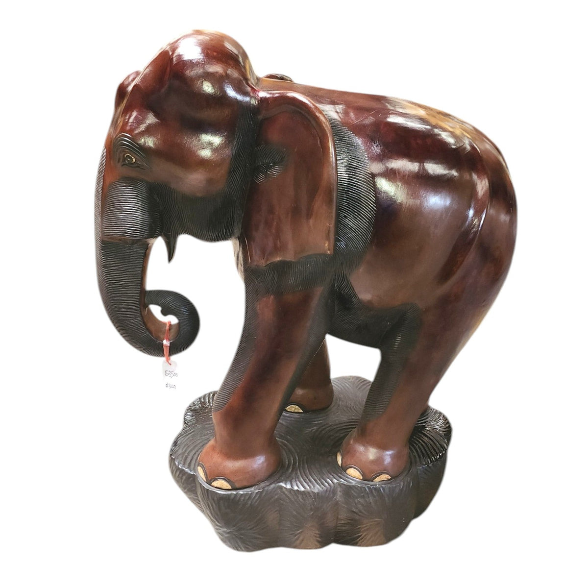 Three-quarter view of the 52-inch carved wood elephant with trunk curled