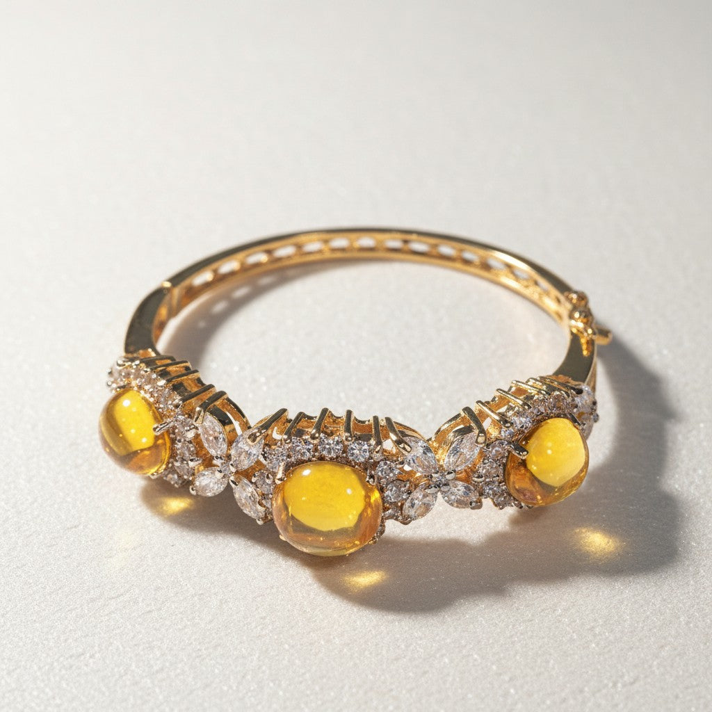 Dipped gold bangle with yellow cabochon stones and clear stone accents, angled view