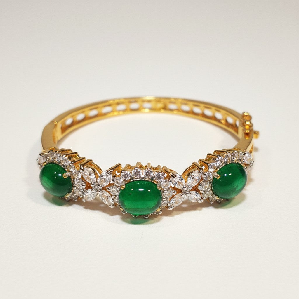 Dipped gold bangle with emerald green cabochon stones and clear stone accents