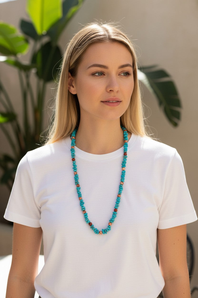 Woman wearing a turquoise necklace with red stone accents