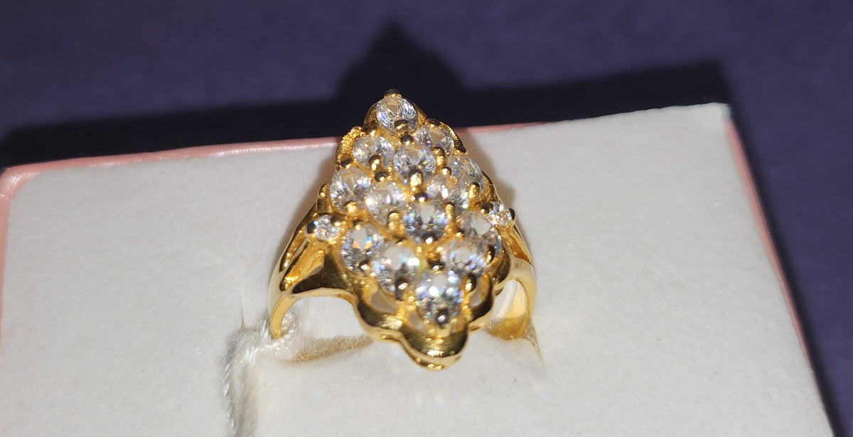 Gold-colored ring with a cluster of clear round stones and a scalloped edge