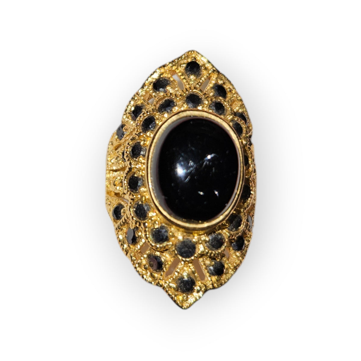 Gold-colored ring with an oval black cabochon and small black stones in an openwork frame