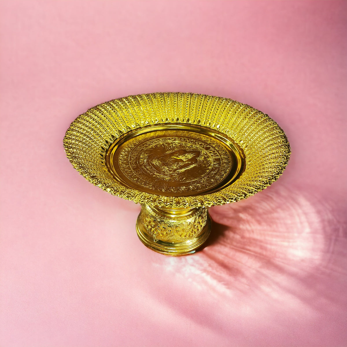 Gold offering tray on a pedestal foot, front view on a pink background