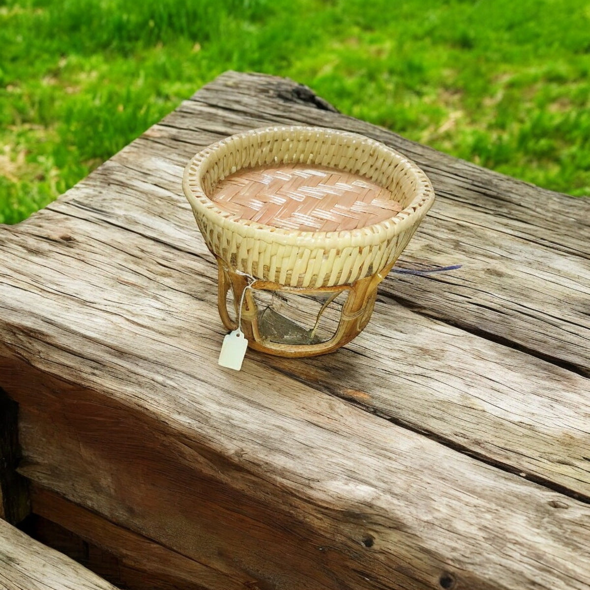 Rattan Khan Toke serving tray table with woven top, small size on a wood bench