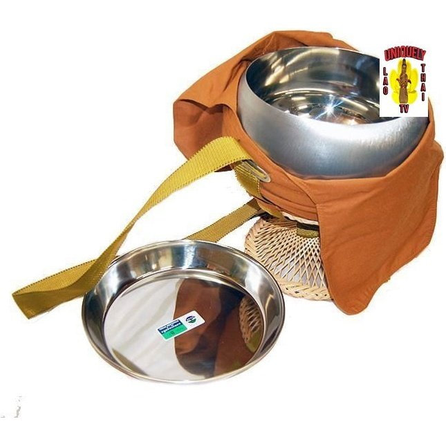 Alms bowl in orange cloth cover with strap on a rattan stand, polished stainless steel plate lying beside it
