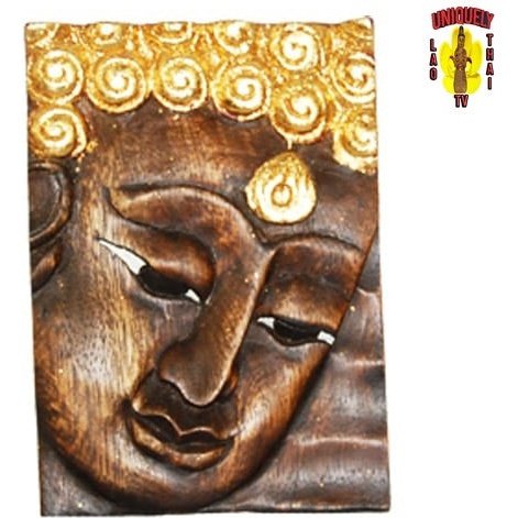 Close view of the carved brown Buddha face plaque with gold curls