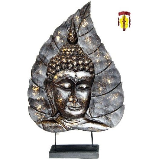 Another view of the black leaf plaque flecked with gold, carved with a Buddha face and mounted on a dark stand