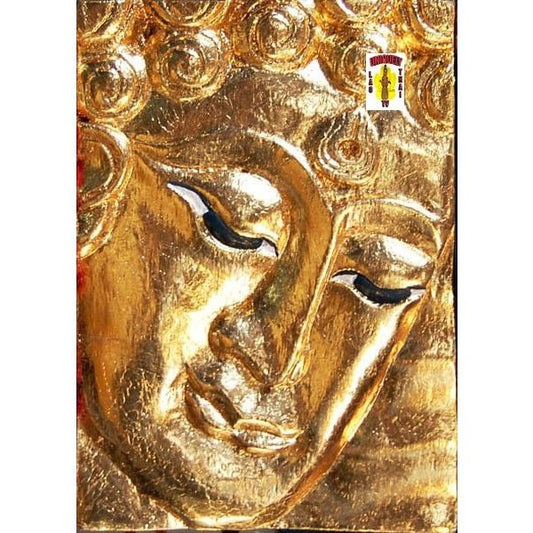 Close view of the gold Buddha face plaque showing the eyes, nose and hair curls