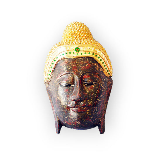 Front view of the carved wood Buddha head on its small feet, gold crown and dark face
