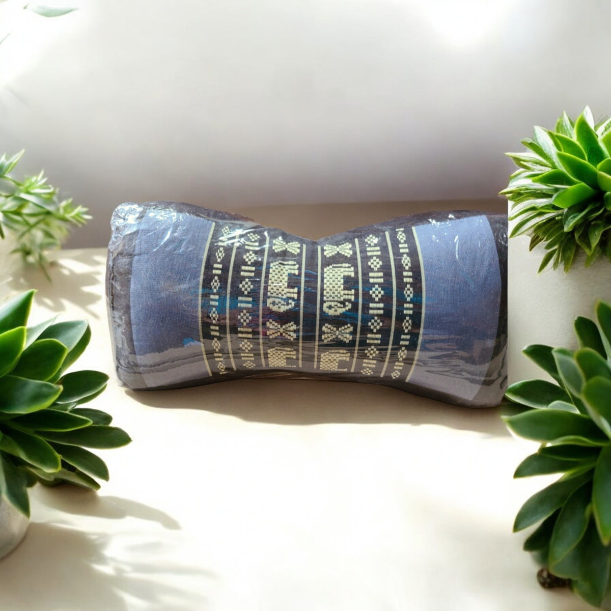 Bone-shaped kapok travel neck pillow in blue elephant pattern, with plants